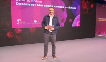imagem do Diretor executivo da Abrale, Fábio Fedozzi, a frente do telão sobre a competição realizada no 7º congresso Todos juntos Contra o Câncer
