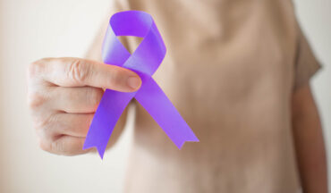 Imagem De Uma Mulher Não Identificada Com O Braço A Frente, Segurando O Laço Da Cor Da Campanha De Conscientização Sobre O Câncer De Colo Do útero