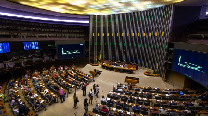 Imagem Interna Da Câmara Dos Deputados Brasileira, Cadeiras Estão Dispostas Em Direção à Mesa Principal