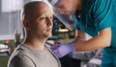 imagem de um paciente oncológico sendo vacinado por um profissional da saúde, em representação aos pacientes com câncer que já podem ser vacinados contra o COVID-19