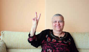 imagem de uma mulher com os dois dedos levantados em sinal de vitória