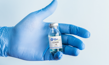 Imagem De Uma Mão Com Luvas Segurando Um Frasco Da Vacina Da Pfizer