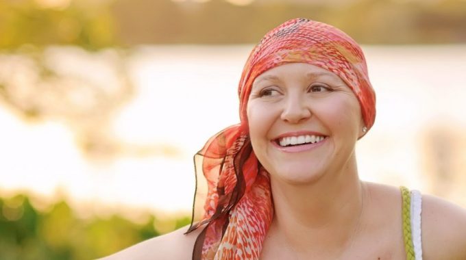 Imagem De Uma Mulher Sorrindo E Com Um Lenço Na Cabeça, Em Relação à Seleção De Histórias Inspiradoras Sobre Câncer