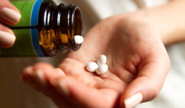 imagem de medicamentos orais sendo despejados em uma mão