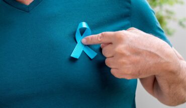 imagem de um homem apontado o dedo para o laço do novembro azul colado em sua camiseta