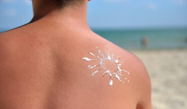 Imagem Das Costas De Um Homem Com Protetor Solar Na Praia