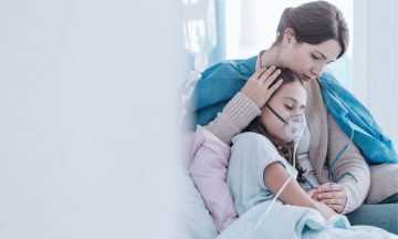 Imagem De Um Profissional Da Saúde Abraçando Uma Criança Hospitalizada