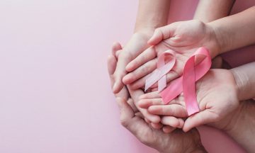 Imagem De Várias Mãos Femininas E Na Palma De Uma Delas Dois Laços Da Cor Da Campanha De Conscientização Do Câncer De Mama