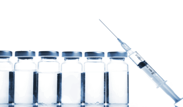 Imagem de quatro ampôlas de medicamento transparente transparente e seringa com agulha.