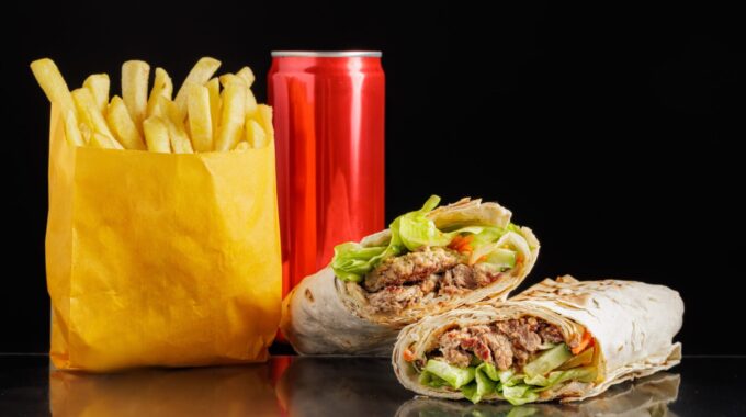 Batata frita, refrigerante e shawarma, representando os alimentos ultraprocessados.